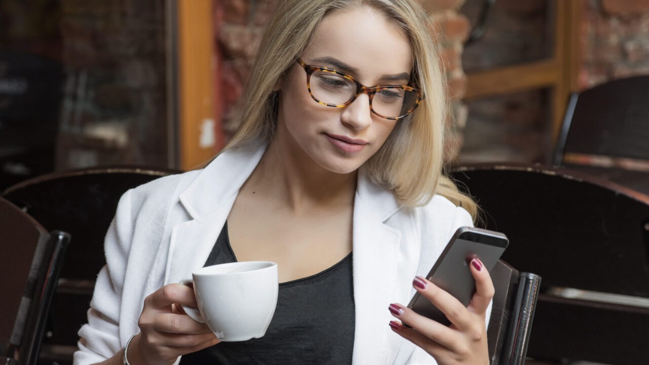 young business woman blonde in glasses in cafe